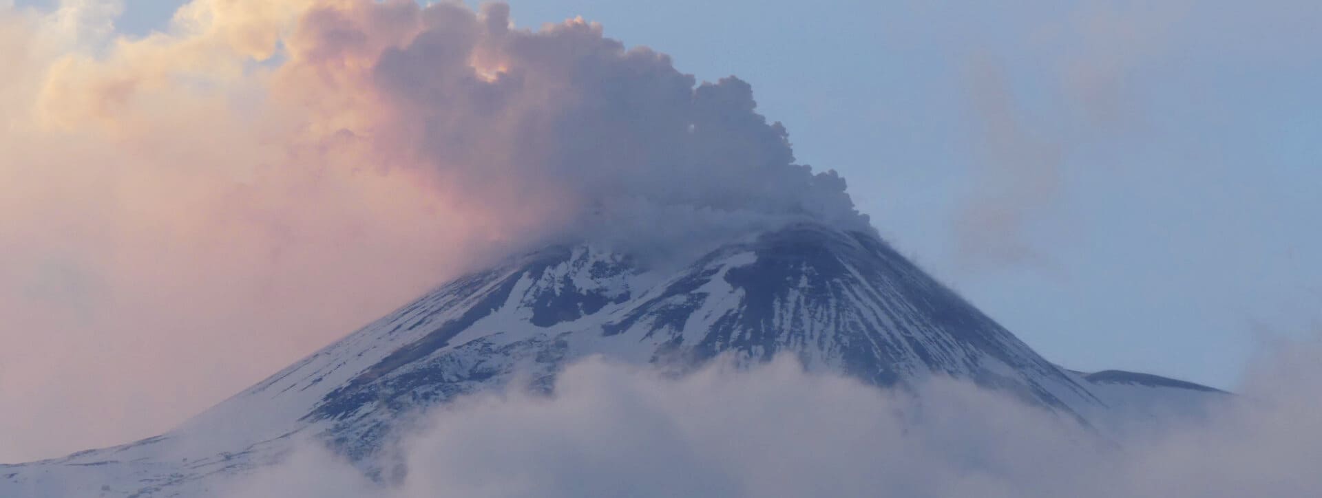 Il cratere sudorientale dell'Etna fuma gas sopra le nuvole